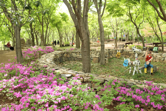 다양한 목각인형과 영산홍이 조화를 이루는 후투티 정원은 사진을 찍기 좋은 곳이다. 남태우 기자