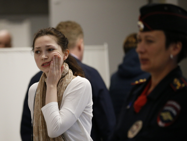 5일(현지 시간) 모스크바 셰레메티예보 공항에서 피해자의 한 친척이 여러 사람이 모여 있는 곳을 떠나면서 울먹이고 있다. AP연합뉴스