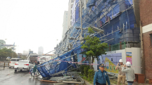 27일 부산 중구 한 공사장 외벽에 설치된 안전펜스가 강풍에 무너지며 도로를 덮치고 있다. 부산경찰청 제공