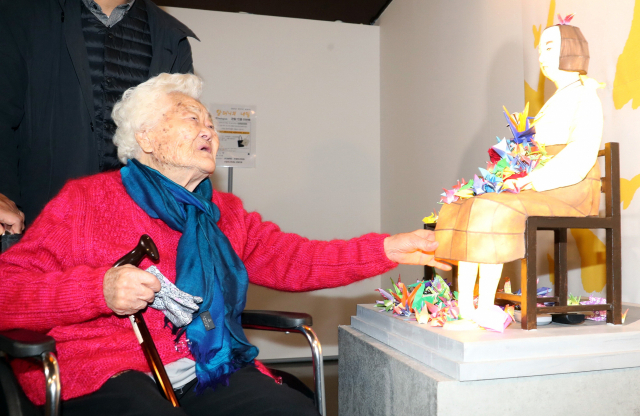 18일 부산 남구 국립일제강제동원역사관을 방문한 위안부 피해자인 이옥선(92) 할머니가 소녀상을 어루만지고 있다. 강원태 기자 wkang@