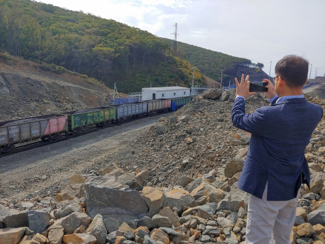 KMI 이성우 본부장이 포디야폴스키 항만 배후 철도 운행 모습을 카메라에 담고 있다.