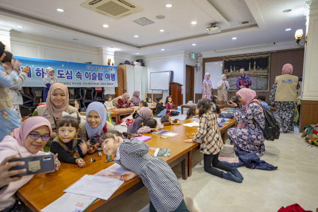 지난달 열린 ‘도심 속 이슬람 여행’ 프로그램에서 말레이시아 대학생들이 아이들과 기념 촬영을 하고 있다. 더휴랩 제공