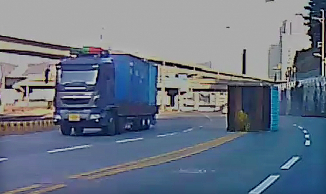 16일 부산 남구 우암로에서 감만동 방면으로 향하던 대형 트럭이 커브길을 돌다 트럭 위에 실린 컨테이너 박스가 떨어져 반대편 차로로 넘어가 있다. 독자제공