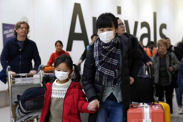 마스크를 착용한 승객들이 22일(현지시간) 영국 런던의 히스로공항 터미널4에 도착하고 있다. 영국 당국은 우한 폐렴 확산에 따른 예방조치로 중국발 항공편에 대한 모니터링에 나섰다. EPA연합뉴스