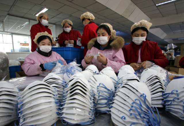 '우한 폐렴'에 대한 중국인들의 우려가 증폭되면서 마스크의 재고가 줄어들고 있는 가운데 허베이 성 한단의 한 마스크 생산 공장에서 23일 직원들이 제품을 챙기고 있다. 연합뉴스