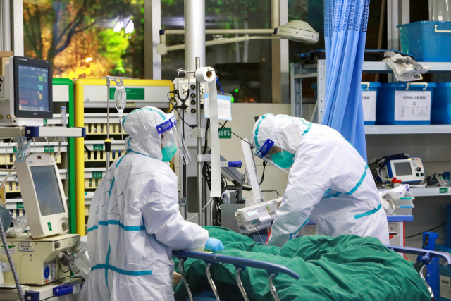 28일(현지시간) 중국 후베이성 우한의 우한대학 부속 중난병원에서 보호복을 입은 의료진이 신종 코로나바이러스에 의한 폐렴 환자를 치료하고 있다. 연합뉴스