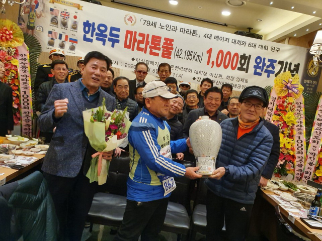 한옥두 부산남해마라톤클럽 고문이 지난달 5일 부산 강서구 대저생태공원에서 1000번째 마라톤 풀코스를 완주하고 축하를 받고 있다.