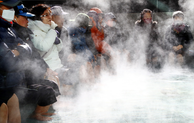 부산 해운대구청 야외 온천족욕장을 찾은 주민들이 따뜻한 온천물에 발을 담근 채 추위와 피로를 풀고 있다. 부산일보DB
