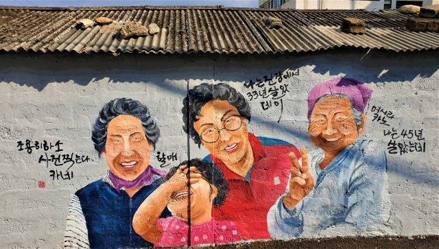 밀양 ‘진장 문화예술의 거리’ 담벼락에 현지 주민들의 모습을 담은 익살스러운 벽화가 그려져 있다.