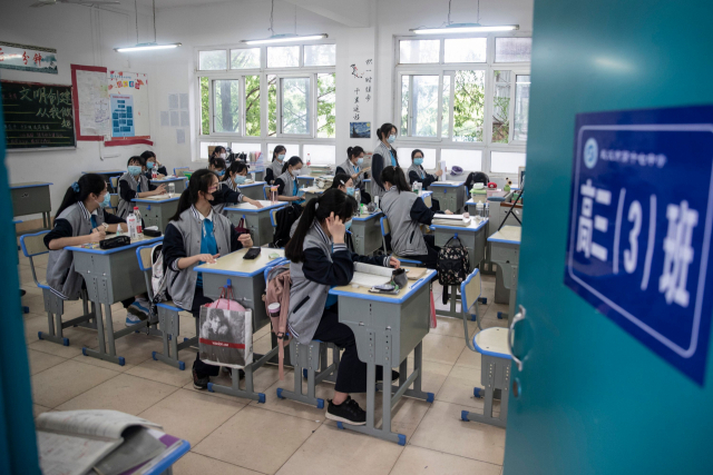 6일(현지시간) 중국 후베이성 우한시의 학교들이 일제히 개학한 가운데, 한 고등학교 3학년 교실에서 마스크를 착용한 학생들이 수업 시작을 기다리고 있다. AFP연합뉴스