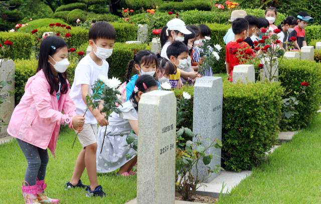 한국전쟁 70주년을 하루 앞둔 24일 오전 부산 남구 유엔기념공원을 찾은 어린이들이 전몰장병 묘역에 헌화하고 있다. 정종회 기자 jjh@