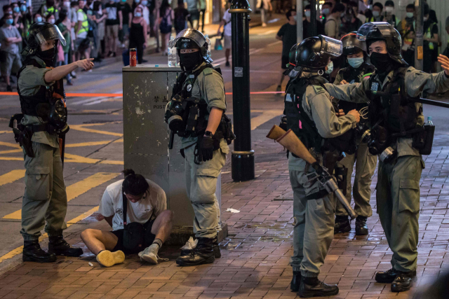 1일 홍콩 도심에서 홍콩보안법을 반대하는 시민들의 시위가 열려 경찰이 370여 명을 체포했다. 한 시위 참가자가 이날 코즈웨이베이 지역 거리에서 경찰에 붙잡혀 바닥에 앉아 있다. EPA연합뉴스