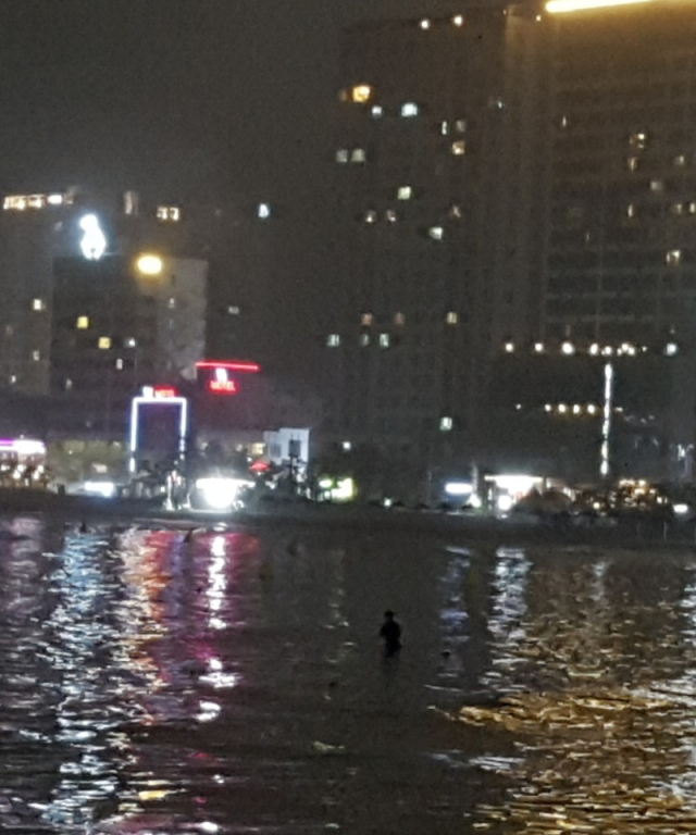 지난 14일 물에 빠진 여성을 구하기 위해 부산 수영구 광안리 바다 속으로 들어가는 박재욱 씨. 독자 제공