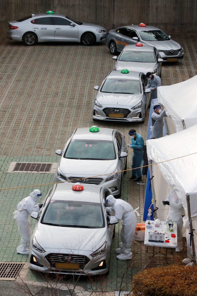 지난 11일 부산아시아드주경기장 주차장에 설치된 ‘찾아가는 이동 선별검사소’에서 택시 운수종사자들이 드라이브스루 방식으로 코로나19 진단을 받고 있다. 김경현 기자 view@