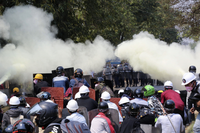 8일(현지시간) 미얀마 수도 네피도에서 군부 쿠데타 규탄 시위대가 최루탄을 쏘며 진압에 나선 경찰을 향해 소화기를 뿌리고 있다. AP연합뉴스