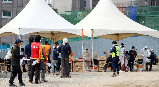 15일 오전 부산 동래구의 한 건설현장에 마련된 이동형 임시선별검사소에서 외국인 노동자들이 코로나19 검사를 받고 있다.정종회 기자 jjh@