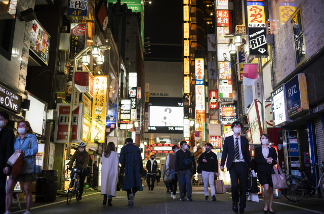 9일 일본 도쿄 신주쿠 길거리에서 시민들이 마스크를 쓴채 걷고 있다. AP연합뉴스