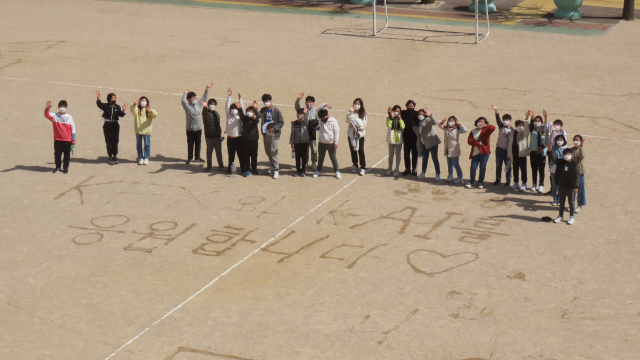 부산 동신초교 6학년 1반 학생들이 학교운동장에서 KAI 응원 메시지를 적고 국산 첫 전투기개발을 응원했다. KAI 제공