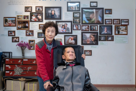 조점순(74) 씨가 중증장애인 아들 박재한(46) 씨와 함께 부산뇌병변복지관 가족캠프 프로그램에 참가해 영화 ‘8월의 크리스마스’ 촬영지인 전북 군산 사진관에서 가족 사진을 찍고 있다. 부산뇌병변복지관 제공