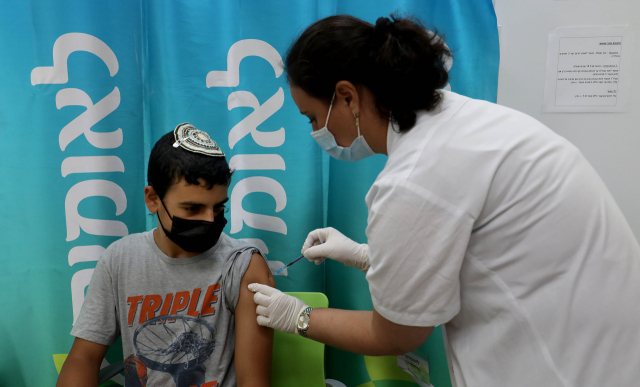 22일(현지시간) 이스라엘 중부 모딘의 한 건강의료센터에서 의료진이 학생에게 코로나19 백신을 접종하고 있다. 신화연합뉴스