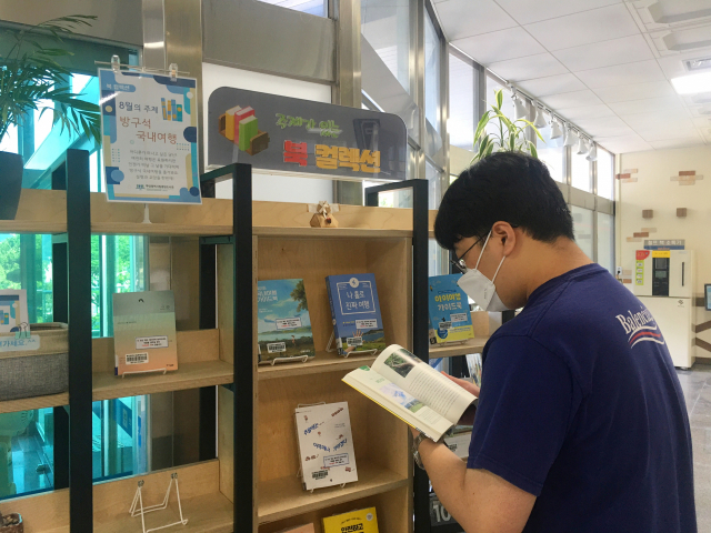 부산중앙도서관 본관 1층 현관에서는 ‘주제가 있는 북컬렉션’ 8월의 주제로 ‘방구석 국내여행’ 도서 14권을 추천·전시해 시민들이 읽도록 권하고 있다. 중앙도서관 제공