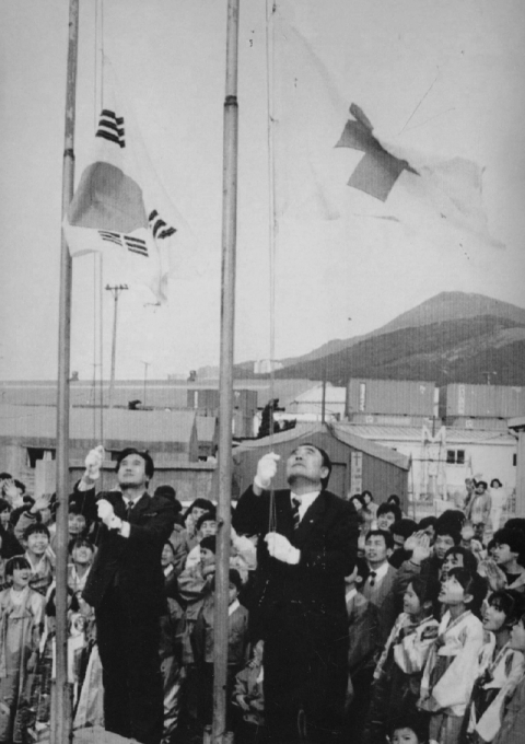 1993년 1월 29일 문을 닫게 된 부산 해운대구 재송동 베트남난민보호소에서 태극기와 적십자기를 내리고 있다. 연합뉴스