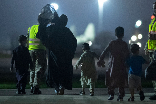 24일(현지시간) 영국 브라이즈 노턴 공군기지에 도착한 아프가니스탄 피란민 가족들이 에어버스 KC2 보이저 항공기에서 내려 이동하고 있다. 앞서 영국은 장기간에 걸쳐 아프간 피란민 2만 명을 수용한다는 계획을 밝혔다. AFP연합뉴스