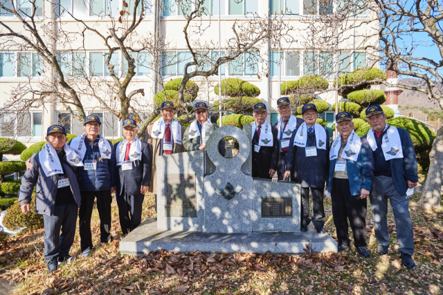 SNT모티브 귀환 행사에 참석한 도미기사들이 회사 내 기념 조형물 앞에서 기념사진을 찍고 있다.