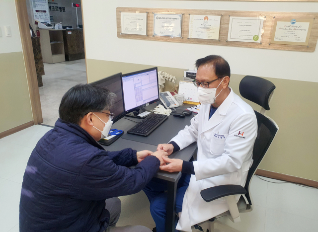 수부외과 분야 권위자인 부산마이크로병원 김용진 박사가 환자를 진료하고 있다. 부산마이크로병원 제공