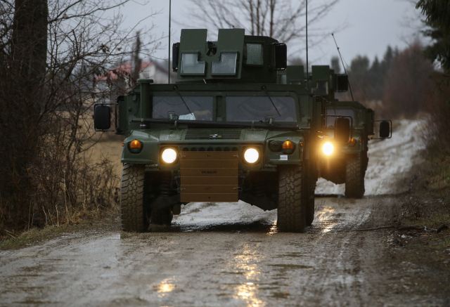 미 육군 제82공수사단 소속 군용 차량(험비)이 23일(현지시간) 우크라이나 접경 지역인 폴란드 동부 아르와모프 인근의 공군기지로 이동하고 있다. 연합뉴스