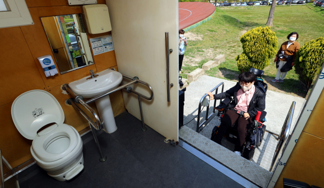 19일 부산 삼락생태공원에서 장애인 관련 단체 활동가들이 리프트가 작동하지 않아 이용할 수 없는 화장실 실태를 보여 주고 있다. 정종회 기자 jjh@