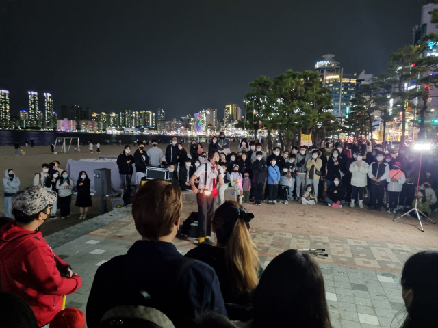 지난달 30일 부산 수영구 광안리해수욕장에서 시민들이 거리 차력쇼를 관람하고 있다.