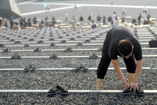 일본군에 의해 노동자들이 맨발로 끌려가 학살 당한 것을 추모하기 위해 중국 난징시의 난징대학살 희생자기념홀 한쪽에 신발 6830켤레를 놓았던 2010년 추모 행사의 한 장면. 부산일보DB