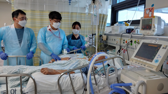 동아대병원 신속대응팀 이동현 팀장(사진 가운데)이 중환자실을 회진하며 환자의 치료방향을 의논하고 있다. 동아대병원 제공