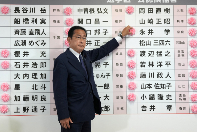 기시다 후미오 일본 총리 겸 자민당 총재가 10일 도쿄 자민당사에서 후보자 이름에 붉은 꽃을 달아 선거 승리를 알리고 있다. 로이터연합뉴스