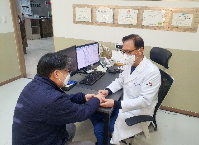 수부외과 분야 권위자인 김용진 의무원장이 환자를 진료하고 있다. 부산마이크로병원 제공