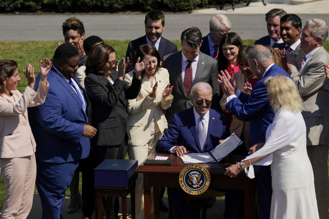 조 바이든(가운데) 미국 대통령이 9일 워싱턴DC 백악관에서 반도체·과학법에 서명한 뒤 웃고 있다. AP연합뉴스연합뉴스