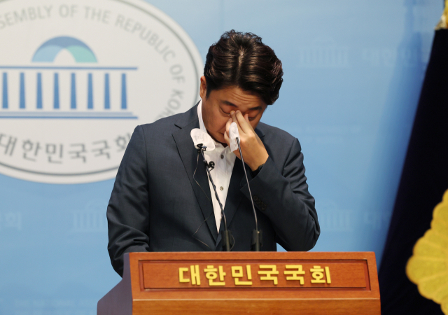 국민의힘 이준석 대표가 13일 국회에서 기자회견을 열고 입장을 밝히던 중 눈물을 닦고 있다. 연합뉴스