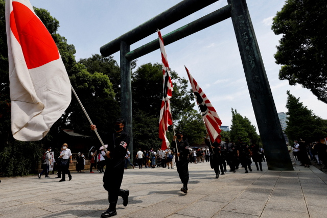 일본 패전일인 15일 우파단체 회원들이 야스쿠니신사에서 퍼포먼스를 하고 있다. 기시다 후미오 일본 총리는 이날 자민당 총재 명의로 야스쿠니신사에 공물을 봉납했다. 로이터연합뉴스