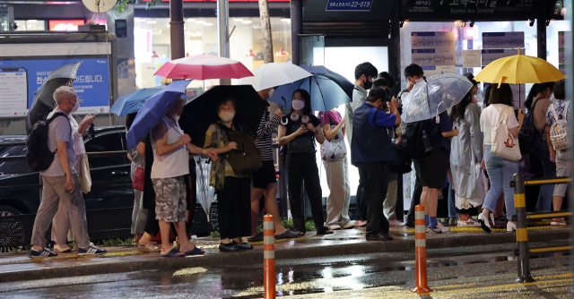 15일 오후 서울 서초구 고속버스터미널 앞에서 우산 쓴 시민들이 발걸음을 옮기고 있다. 연합뉴스