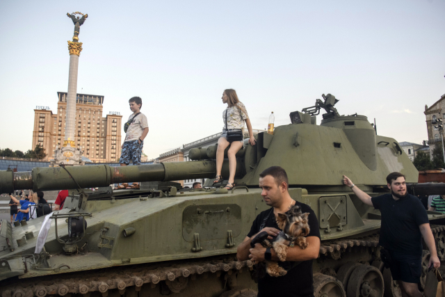 우크라이나 키이우 시민이 21일 거리에 전시된 러시아군 장비 위에 올라가 있다. UPI연합뉴스