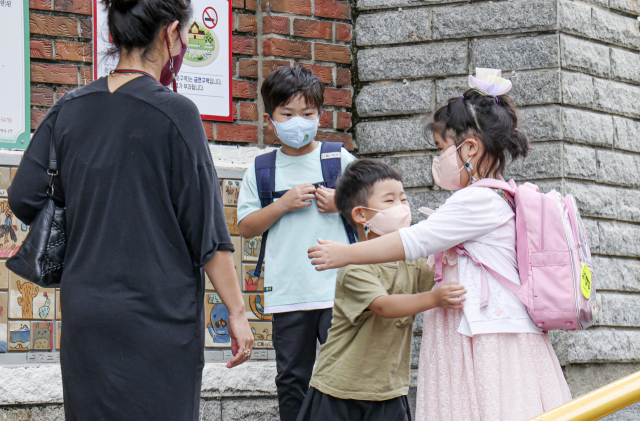 부산지역 대부분의 학교가 개학한 1일 오전 부산 동구 수정초등학교 교문 앞에서 방학이 끝나 등교를 하는 누나와 동생이 포옹을 하며 인사를 나누고 있다.