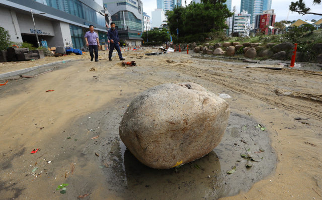6일 오전 부산 서구 송도해수욕장 해변로에 강한 파도에 떠밀려 온 바위가 놓여 있다. 정종회 기자 jjh@