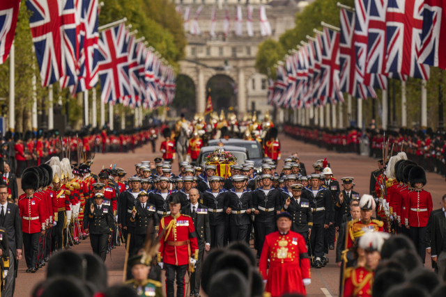 19일(현지시간) 런던 웨스트민스터 사원에서 장례식을 마친 뒤 엘리자베스 2세 영국 여왕의 관이 포차에 실려 버킹엄궁 인근 거리를 지나고 있다. AP연합뉴스