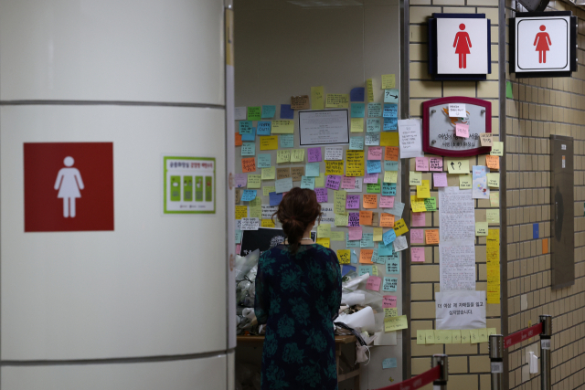 스토킹 살인 사건이 발생한 서울 지하철 2호선 신당역에서 20일 한 시민이 여자화장실 입구에 마련된 추모 공간을 찾아 고인을 추모하고 있다. 연합뉴스