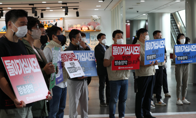 28일 국민의힘 의원들이 MBC를 항의 방문하자 전국언론노동조합 MBC본부 노조원들이 피켓을 들고 있다. 연합뉴스