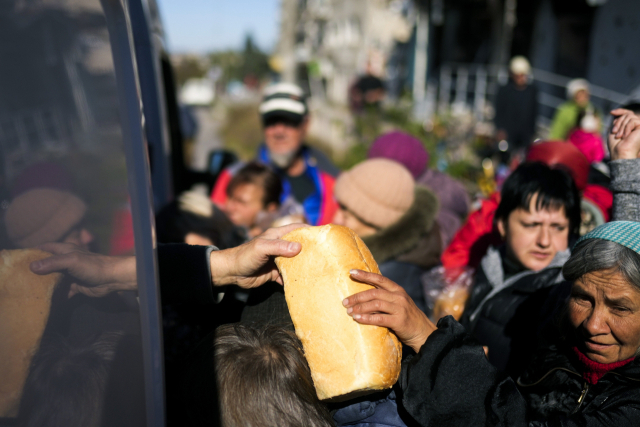 12일(현지시간) 우크라이나 동북부 하르키우주 이지움에서 자원봉사자들이 주민들에게 식량과 생필품을 나눠주고 있다. 이지움 주민들은 지난달부터 연료와 전기, 수돗물 공급 없이 살고 있다. AP연합뉴스