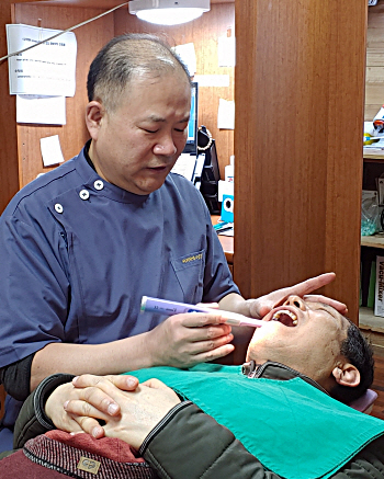 잇몸 뼈가 약해 임플란트 시술이 어려운 경우 발치한 자신의 치아를 이용해 부족한 뼈를 보강할 수 있다. 김경진 원장이 환자를 진료하고 있다. 덴타피아치과의원 제공