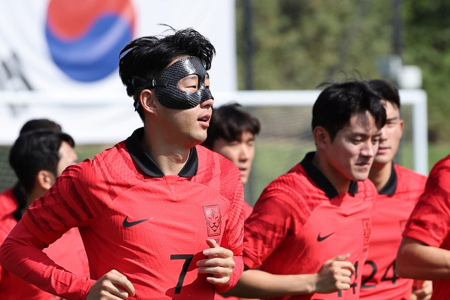 2022 카타르 월드컵에 출전하는 한국 축구 국가대표팀의 손흥민이 16일(한국시간) 카타르 도하의 알에글라 훈련장에서 안면보호 마스크를 착용한 채 동료들과 훈련하고 있다. 연합뉴스