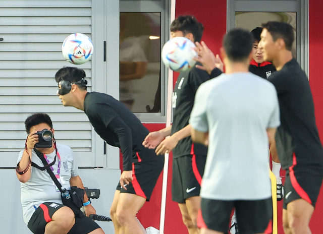 2022 카타르 월드컵에 출전하는 한국 대표팀이 21일(현지시간) 카타르 도하의 알 에글라 훈련장에서 공식 훈련을 진행하고 있다. 안면 보호 마스크를 쓴 채 헤더 훈련을 하는 손흥민. 연합뉴스